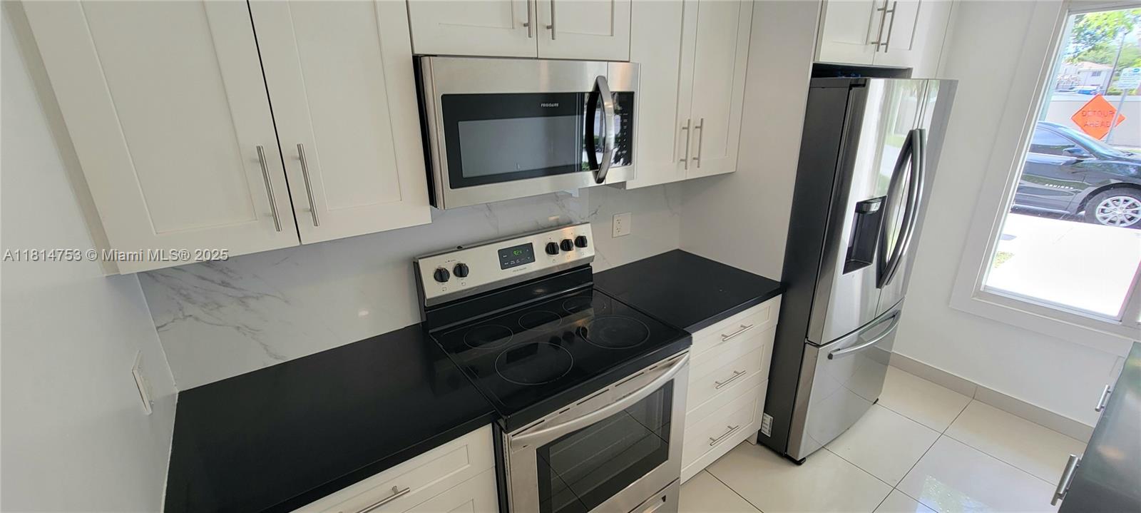 14004 Southwest 259th Street, Unit 14004 Homestead, FL 33032 - Photo 10 of 38 a kitchen with a stove microwave and refrigerator