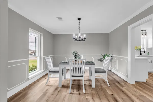a dining room with furniture a chandelier and wooden floor