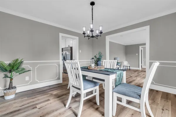 a view of a dining room with furniture wooden floor and chandelier