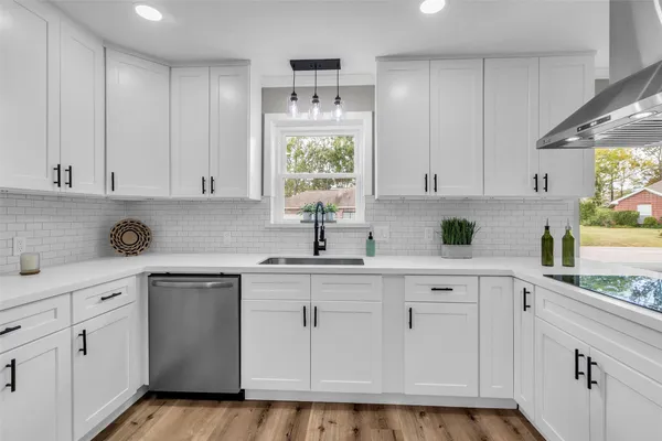 a kitchen with white cabinets white appliances and sink