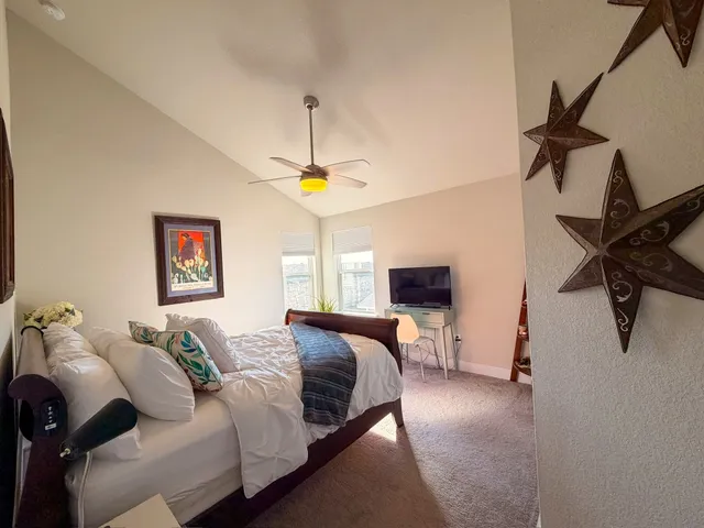 a spacious bedroom with a bed and a chandelier