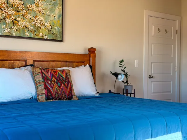 a bedroom with a bed and a painting on the wall