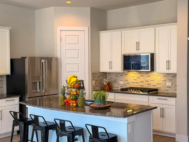 a kitchen with stainless steel appliances granite countertop a stove and a dining table