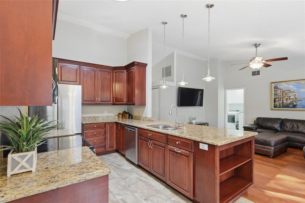 3488 Ridge Boulevard Palm Harbor, FL 34684 - Photo 9 of 30 a kitchen with stainless steel appliances granite countertop a stove a sink and a refrigerator
