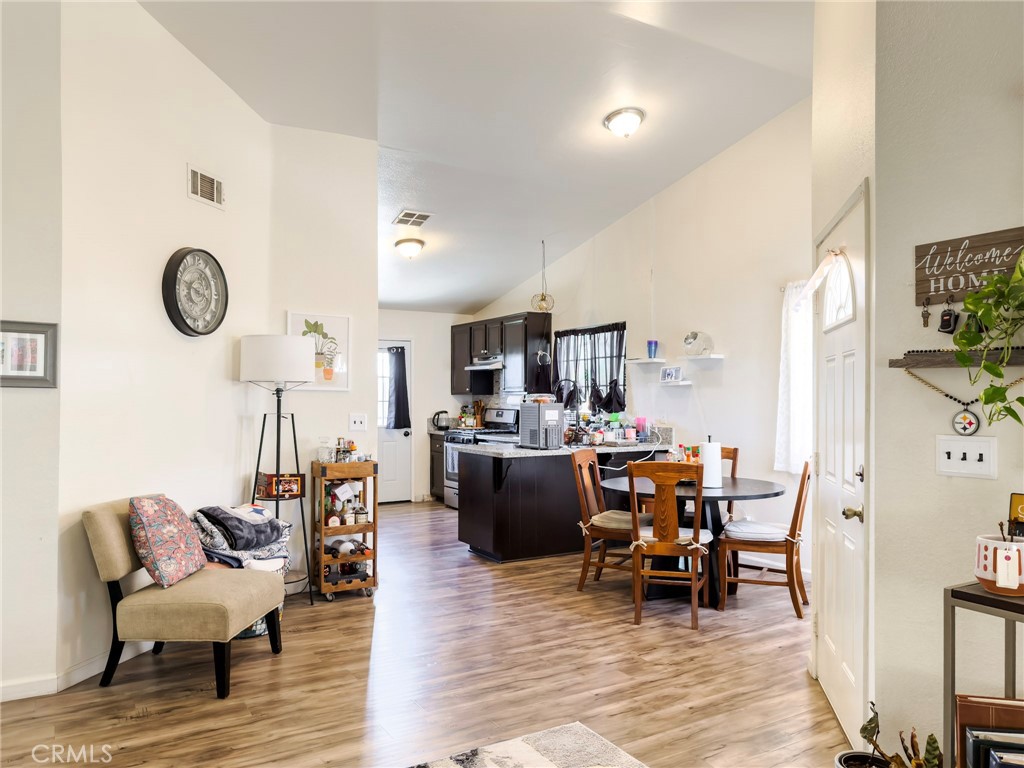 1738 The Willows Road San Jacinto, CA 92583 - Photo 18 of 34 a view of a dining room and livingroom with furniture wooden floor a rug and a clock