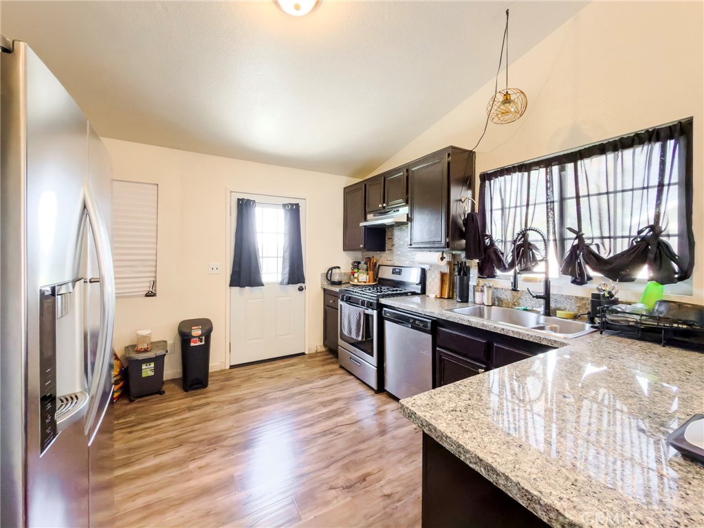 1738 The Willows Road San Jacinto, CA 92583 - Photo 19 of 34 a kitchen with granite countertop a stove and cabinets