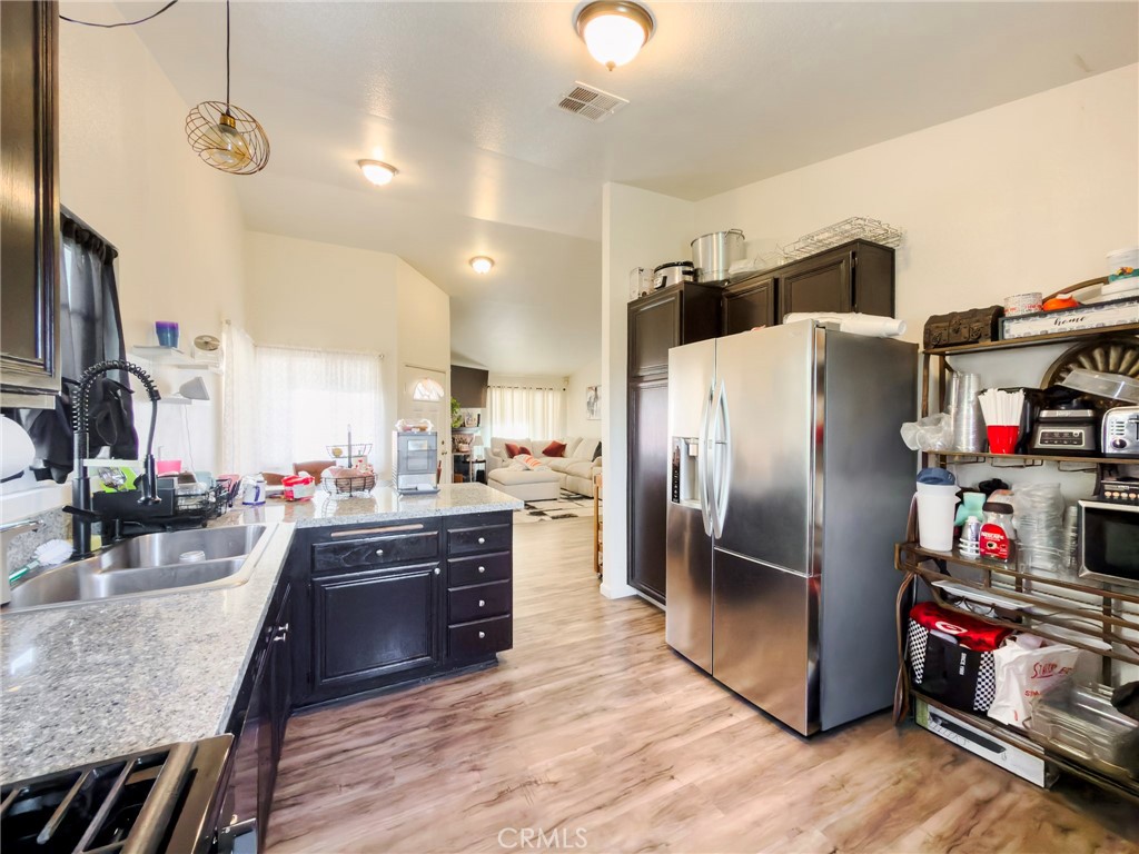 1738 The Willows Road San Jacinto, CA 92583 - Photo 20 of 34 a kitchen with refrigerator and wooden floor