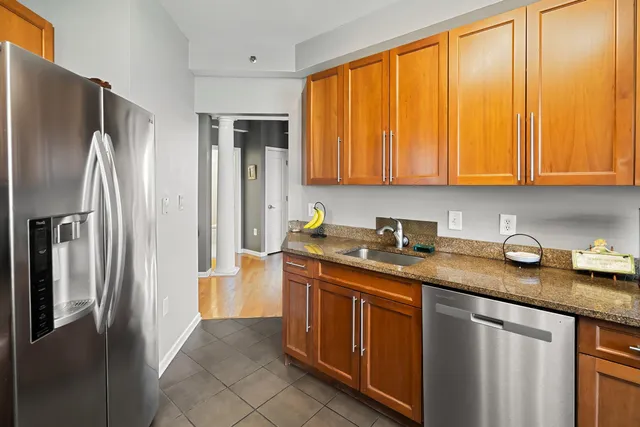 a kitchen with stainless steel appliances granite countertop a refrigerator and a sink