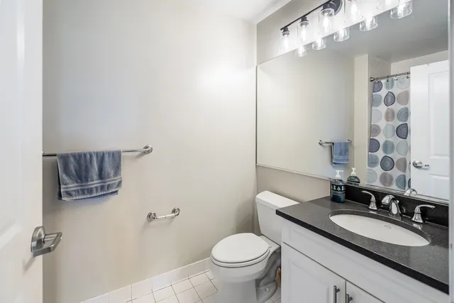 a bathroom with a granite countertop sink a toilet and a mirror