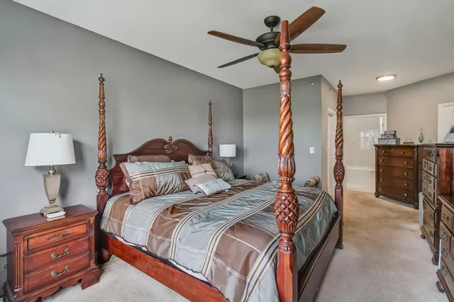 a bedroom with a bed and a lamp on the dresser