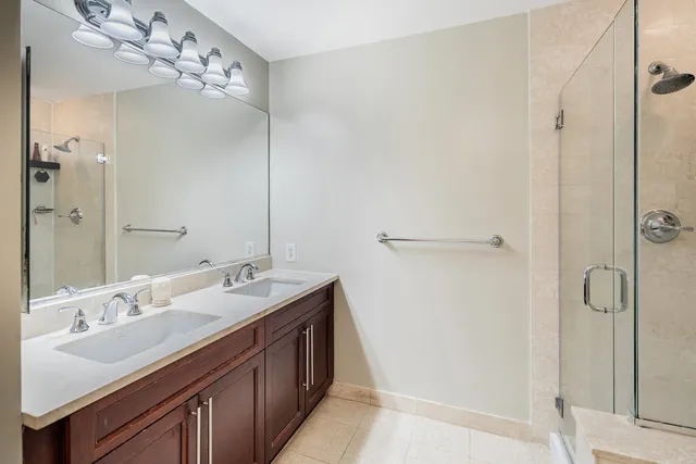 a bathroom with a double vanity sink mirror and shower
