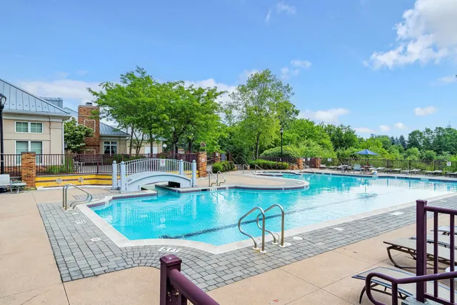 a view of a swimming pool with a patio and a yard