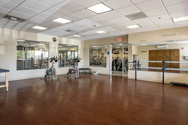 a view of a room with lots of dining table chairs and wooden floor