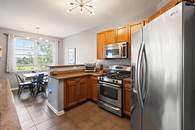 a kitchen with stainless steel appliances granite countertop a stove top oven a sink and a refrigerator
