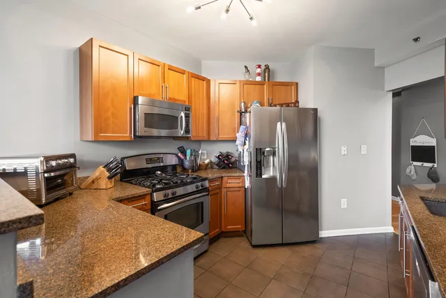 a kitchen with stainless steel appliances granite countertop a refrigerator stove top oven a sink and dishwasher