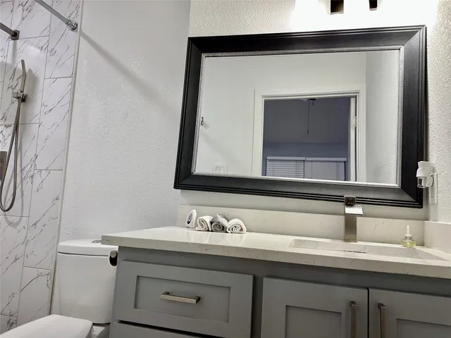 a bathroom with a toilet sink and mirror
