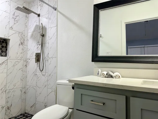 a bathroom with a sink toilet and shower