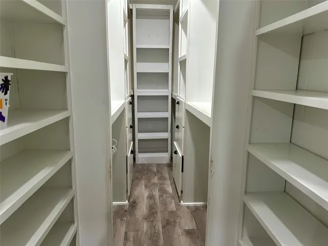 a view of walk in closet with empty racks