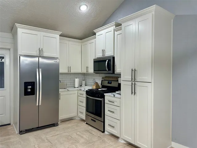 a kitchen with a refrigerator stove and microwave