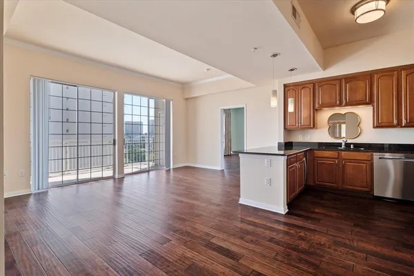 a kitchen with granite countertop a stove top oven a sink and a granite counter tops with wooden floors