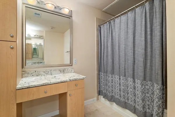 a bathroom with a granite countertop sink and a mirror