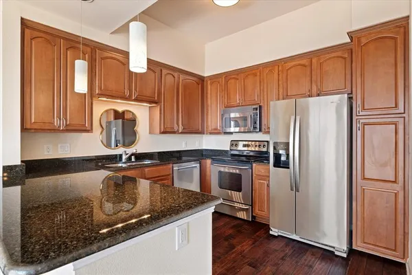 a kitchen with granite countertop a refrigerator stove and sink