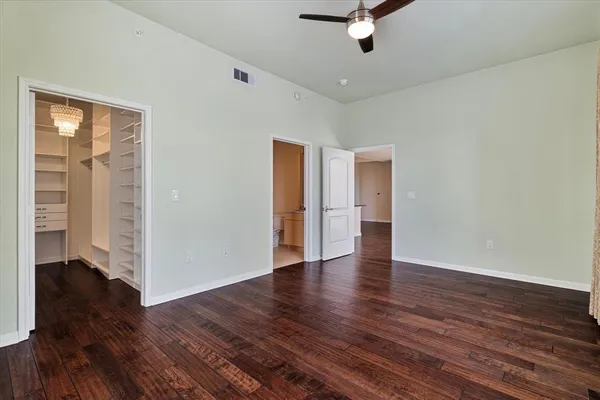 a view of a livingroom with wooden floor and a ceiling fan