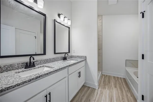 a bathroom with a granite countertop sink toilet and large mirror