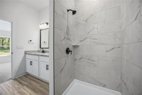a bathroom with a shower sink and mirror