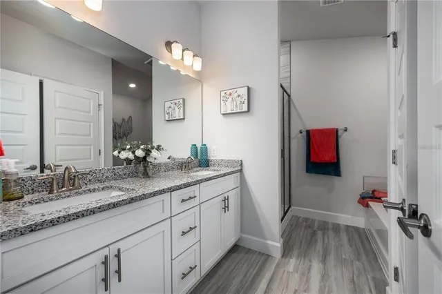 a bathroom with a sink vanity granite and a mirror