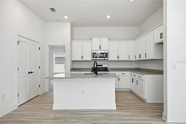 a kitchen with stainless steel appliances granite countertop a sink stove and refrigerator