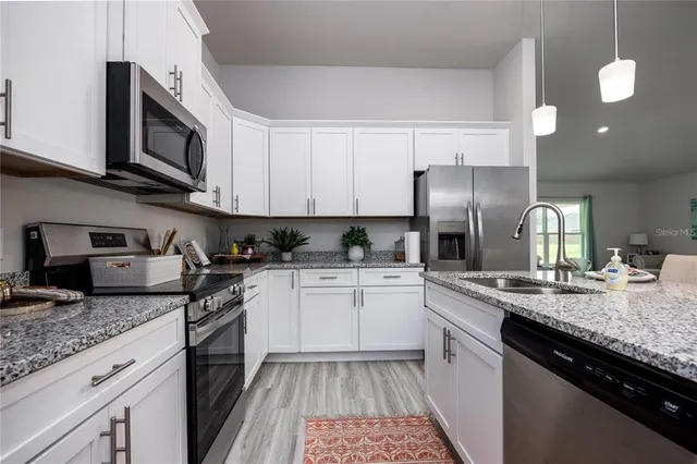 a kitchen with granite countertop stainless steel appliances and sink