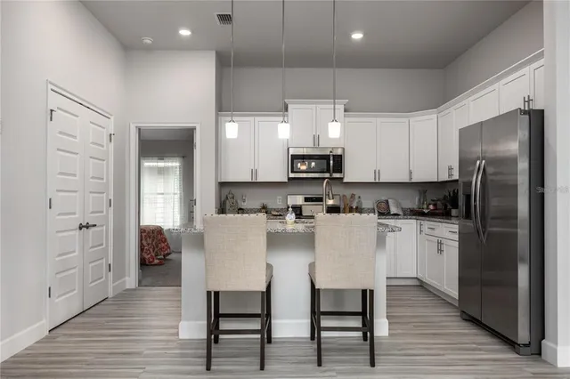 a kitchen with stainless steel appliances a refrigerator sink and white cabinets