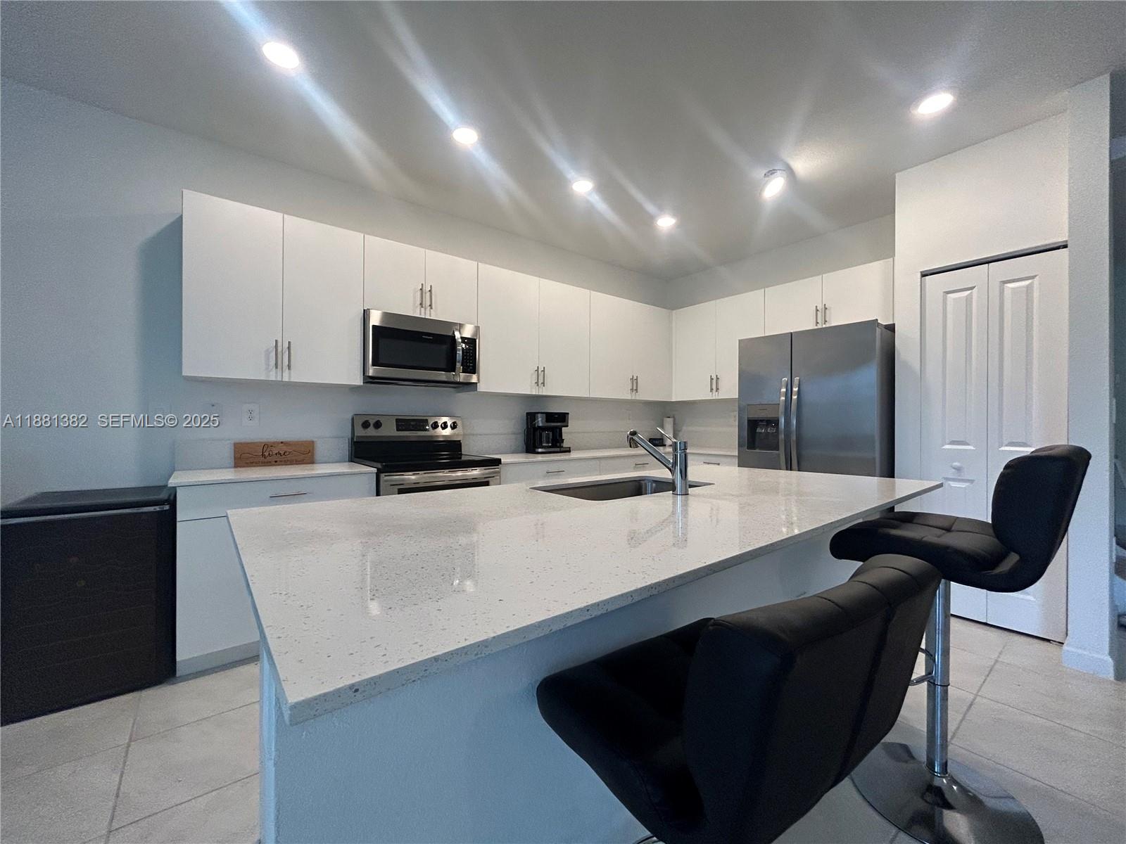 24030 Southwest 119th Place Homestead, FL 33032 - Photo 2 of 15 a kitchen with stainless steel appliances granite countertop a sink a stove a refrigerator a microwave a counter top and cabinets