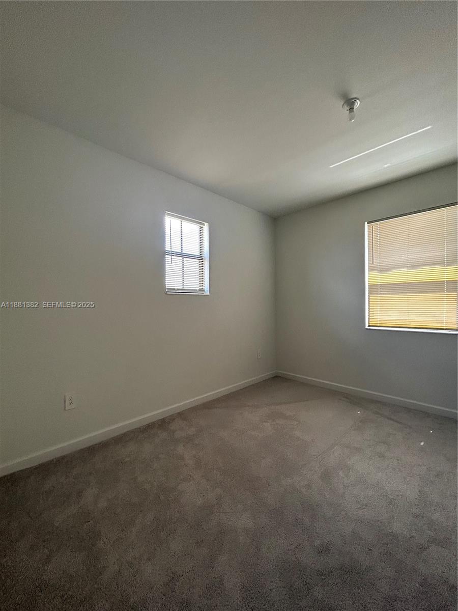 24030 Southwest 119th Place Homestead, FL 33032 - Photo 7 of 15 an empty room with windows