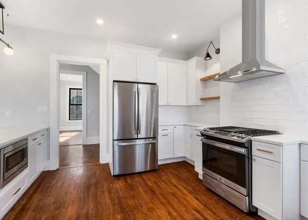 a kitchen with stainless steel appliances wooden floor sink and wooden cabinets