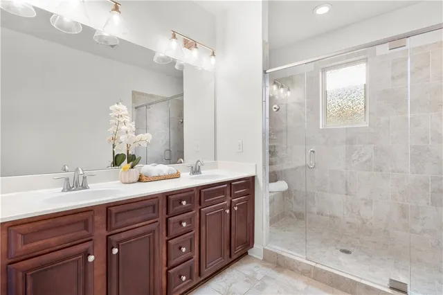 a spacious bathroom with double sink shower and a mirror