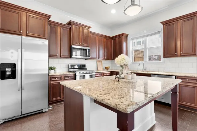a kitchen with stainless steel appliances granite countertop a sink stove and refrigerator