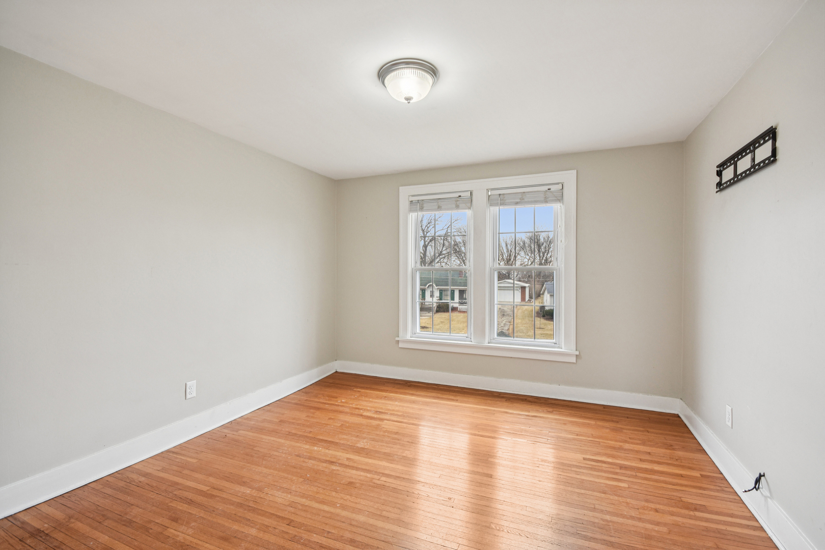 1246 Wauponsee Street Morris, IL 60450 - Photo 20 of 45 a view of an empty room with wooden floor and a window