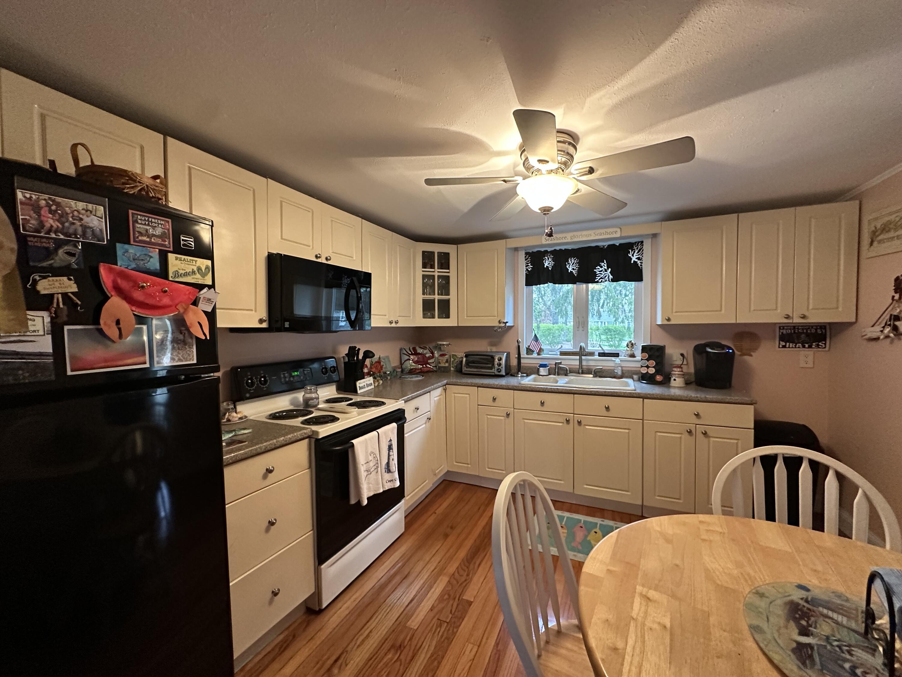 39 Naushon Road Dennis Port, MA 02639 - Photo 11 of 24 a kitchen with stainless steel appliances granite countertop a stove top oven a sink dishwasher and white cabinets with wooden floor