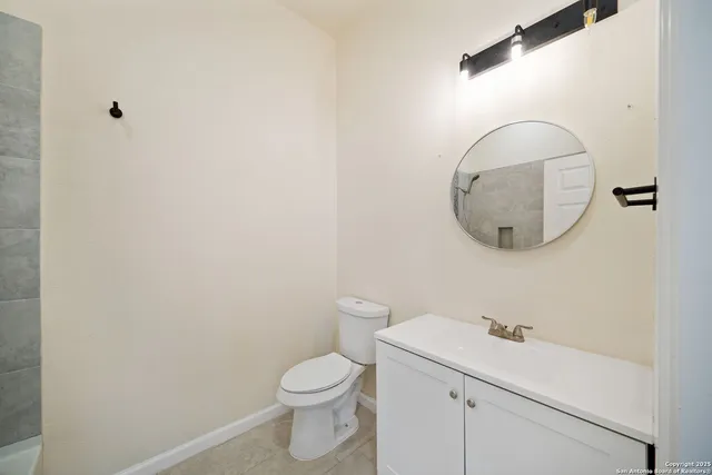 a bathroom with a toilet a sink and mirror