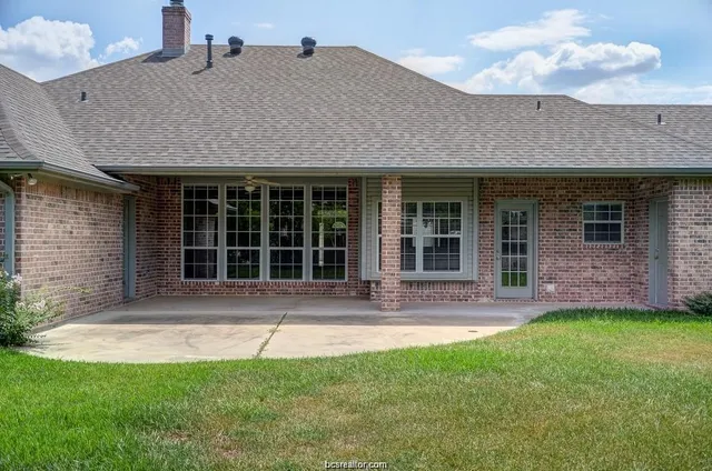 a front view of a house with a yard and glass windows