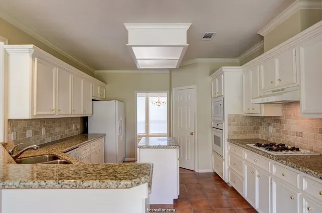 a kitchen with stainless steel appliances granite countertop a stove a sink and a refrigerator