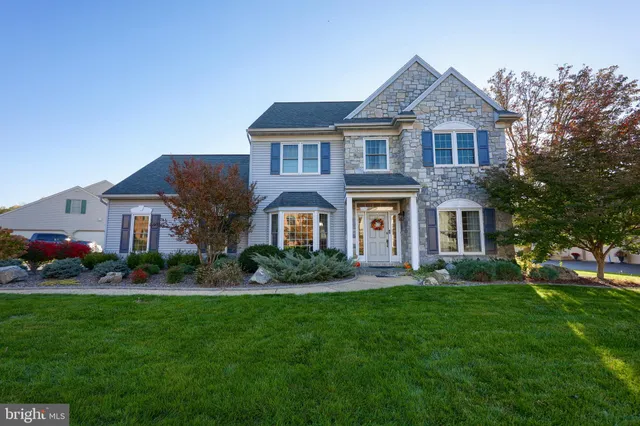 a front view of a house with a garden and plants