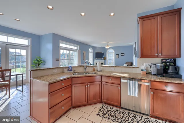 a kitchen with stainless steel appliances granite countertop a stove a sink dishwasher and a microwave oven with cabinets