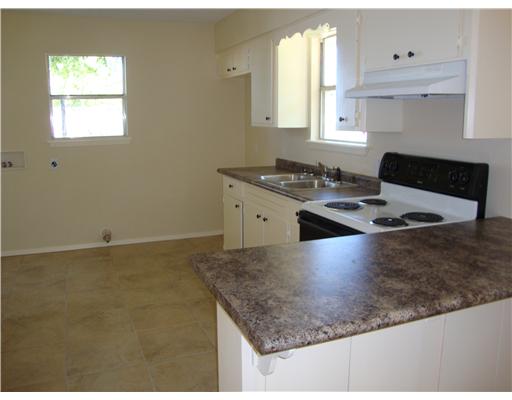 1313 7th Street Corpus Christi, TX 78404 - Photo 2 of 7 a kitchen with stainless steel appliances granite countertop a sink stove and white cabinets
