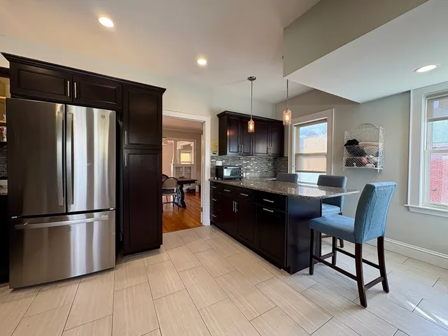 a kitchen with granite countertop a refrigerator and a sink