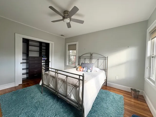 a bed sitting in a spacious bedroom next to a window