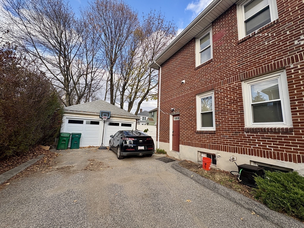 569 Commonwealth Avenue, Unit 2 Newton, MA 02459 - Photo 20 of 21 a car parked in front of a brick house with large windows