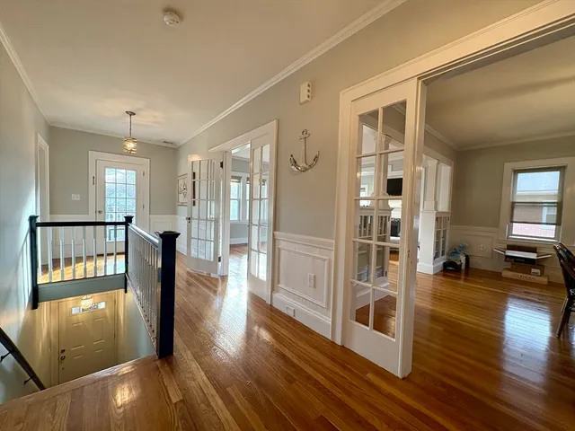 a view of a hallway with wooden floor and a living room